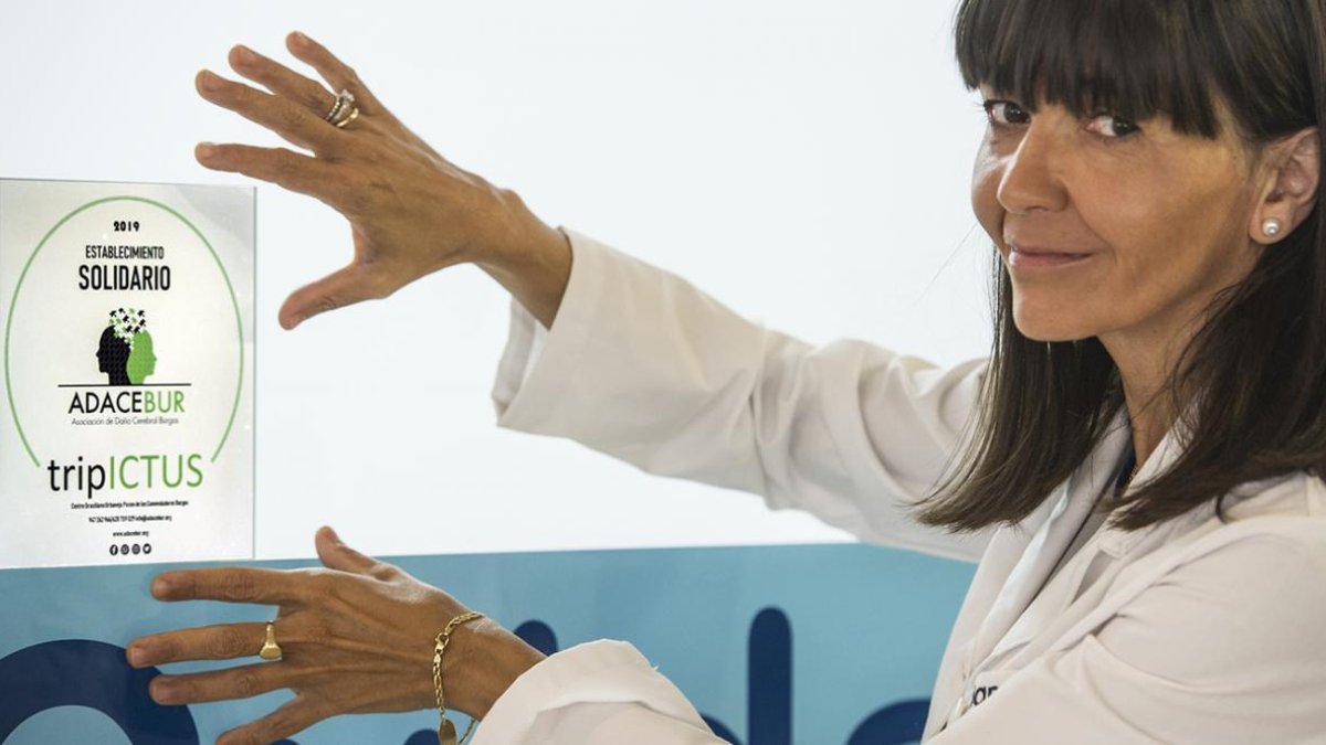 Silvia Caballero, directora de Cuidamos Burgos, muestra la pegatina de local colaborador de  la campaña ‘Establecimientos Solidarios’ de Adacebur.-ISRAEL L. MURILLO