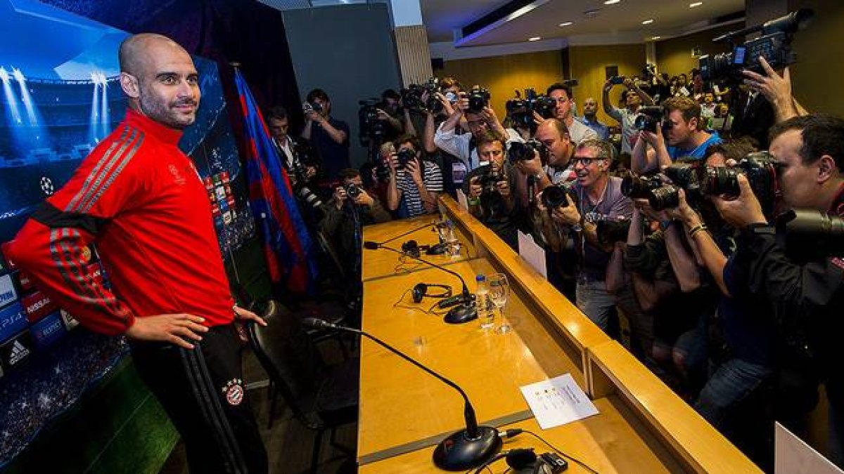 Pep Guardiola, rodeado de periodistas, antes de comenzar la rueda de prensa previa a la semifinal europea en el Camp Nou.-JORDI COTRINA