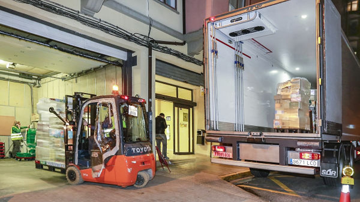 Un camión de reparto desarga su mercancía a las puertas de un supermercado.  / RAÚL OCHOA