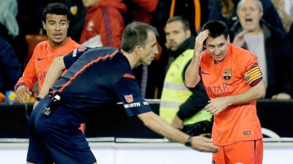 Leo Messi se lamenta tras recibir el impacto de una botella en Mestalla.-Foto: EFE / JUAN CARLOS CÁRDENAS