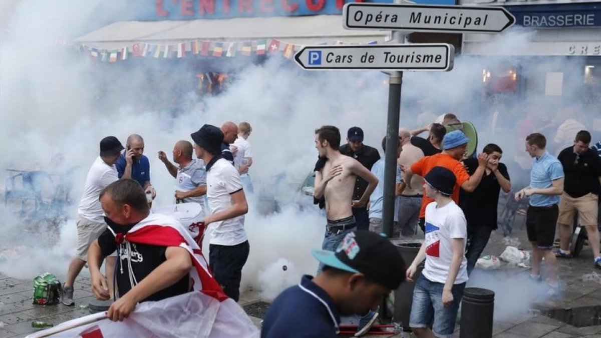 Aficionados ingleses corren tras el lanzamiento de gases lacrimógenos por la policía en Marsella.-DARKO BANDIC