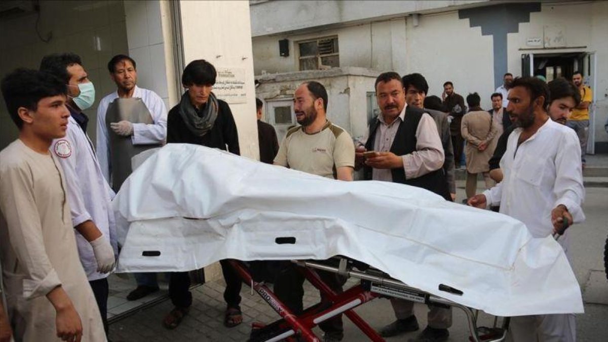 Voluntarios afganos trasladan un cuerpo en una camilla hacia el hospital.-AFP