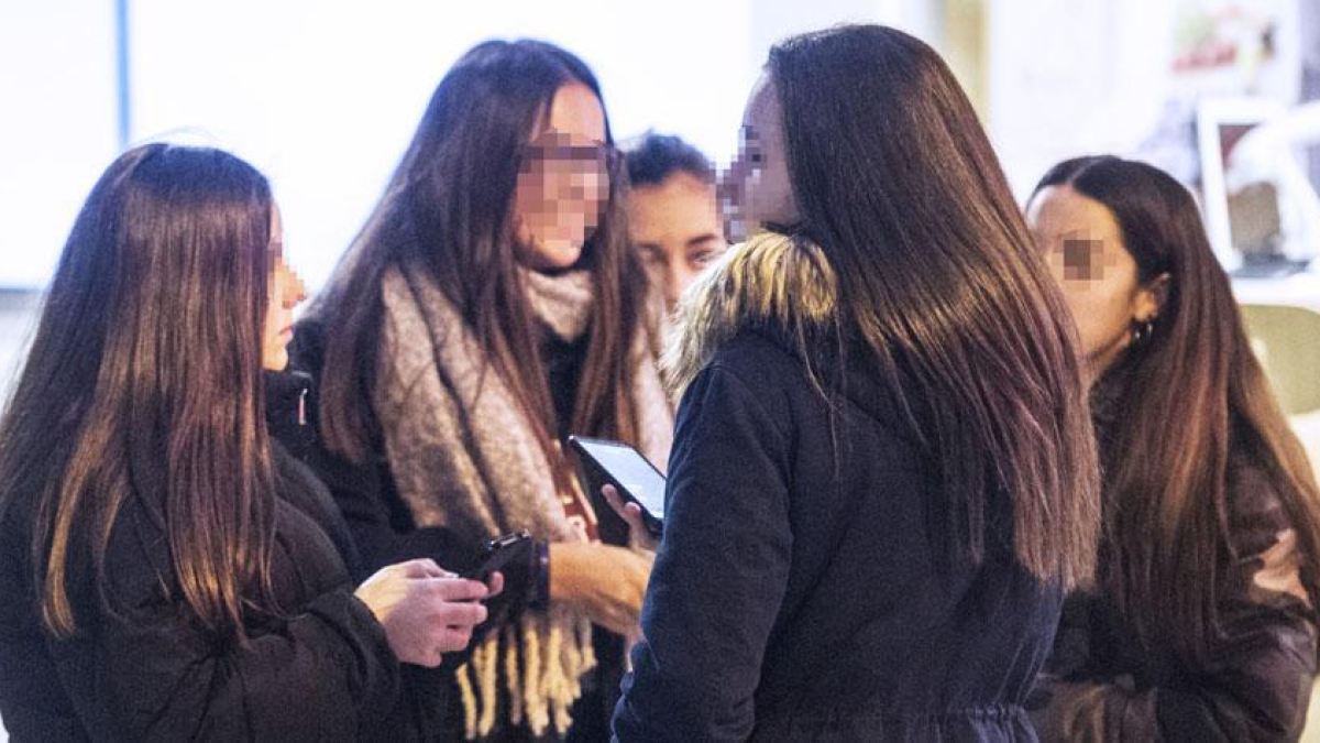 Un grupo de chicas conversa y observa sus teléfonos.-ISRAEL L. MURILLO