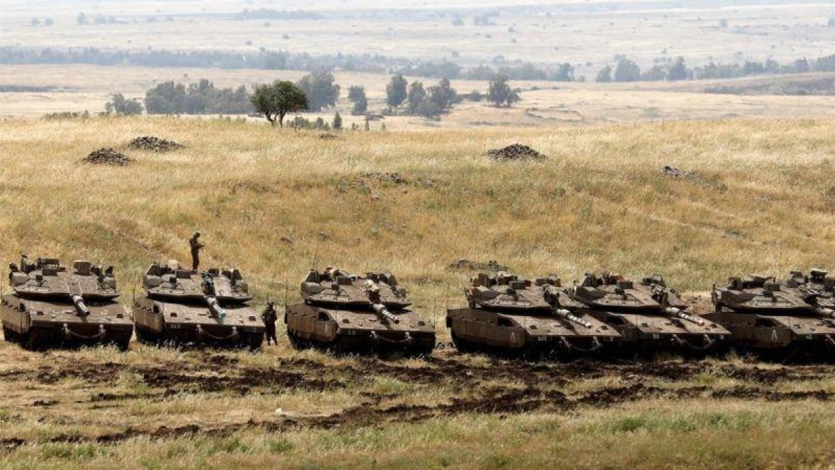 Tanques israelís desplegados este jueves en la frontera que separa los Altos del Golán, territorio ocupado por Israel, y Siria.-AP / MENAHEM KAHANA