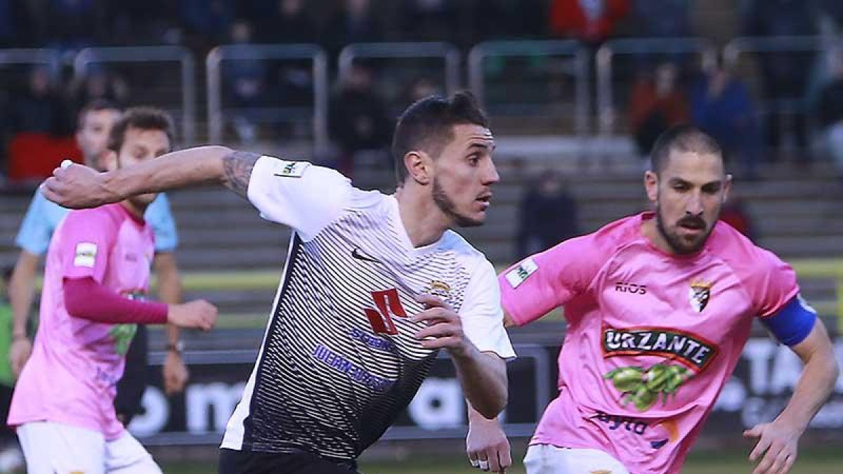 Adrián Cruz conduce el balón en el choque contra el Tudelano.-RAÚL G. OCHOA