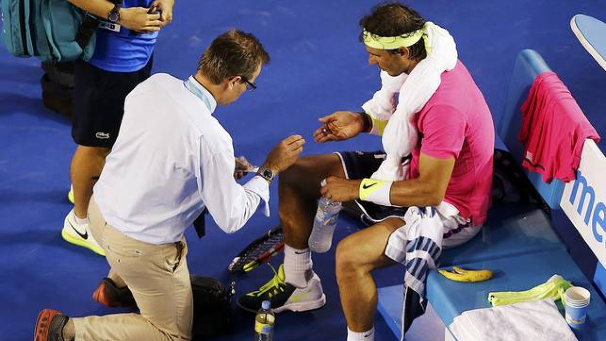 Rafael Nadal es atendido por un médico durante el partido contra Tim Smyczek, durante la segunda ronda del Abierto de Australia.-Foto: REUTERS / CARLOS BARRIA