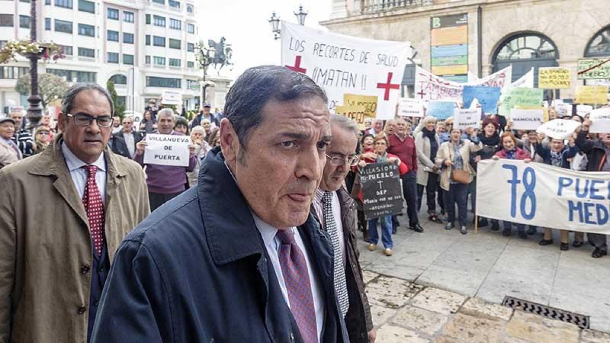 El consejero de Sanidad, Antonio María Sáez Aguado, ante decenas de vecinos reclamando más facultativos en Villadiego.-ICAL
