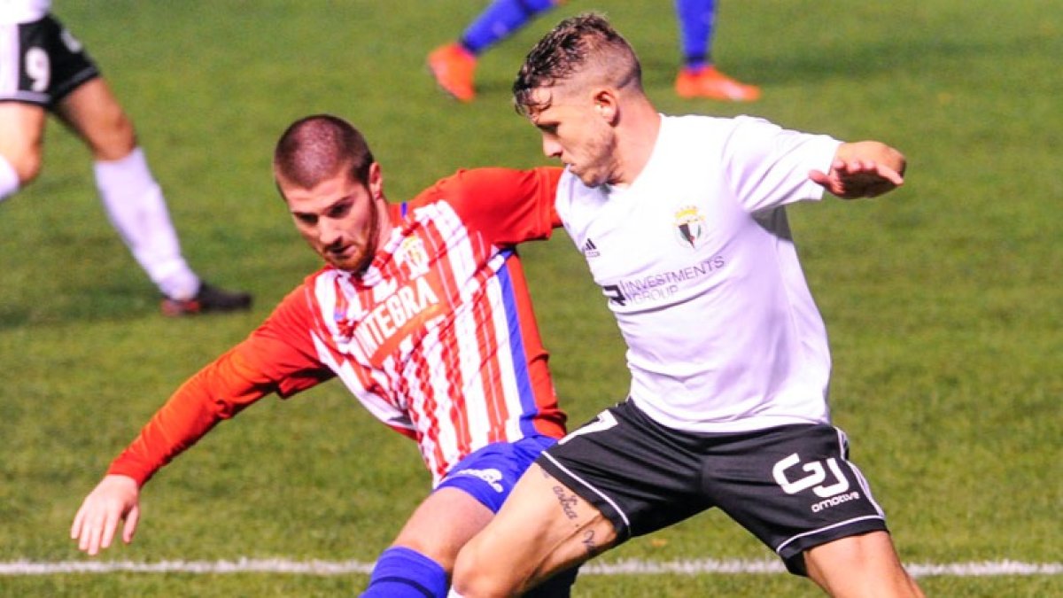 Juanma, muy bullicioso en los primeros minutos, pugna por un balón con un defensor del Sporting B. ISRAEL L. MURILLO