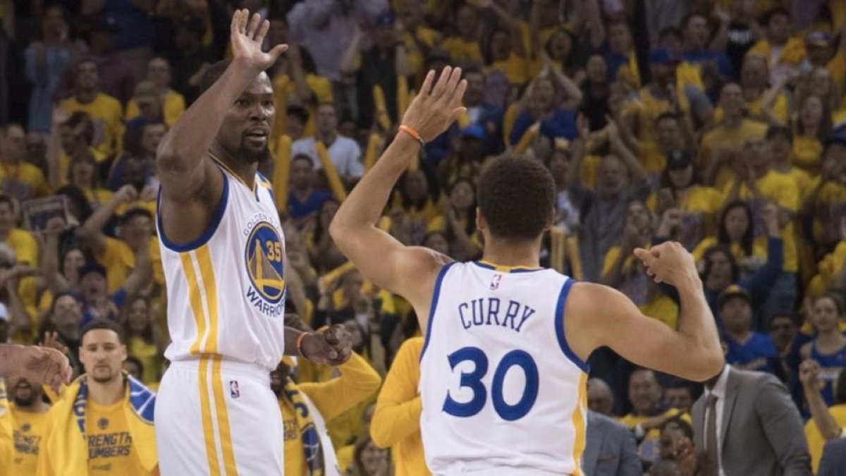 Durant y Curry se felicitan por la victoria ante los Spurs (113-111).-