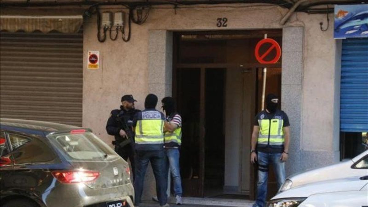 Agentes de la Policía Nacional montan guardia en la puerta del domicilio de uno de los presuntos yihadistas detenidos este miércoles en Canovelles (Barcelona).-ACN / JORDI PUJOLAR