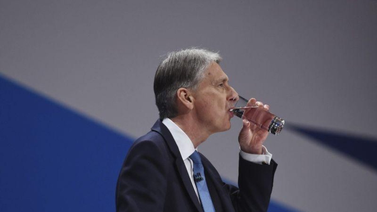 El ministro británico de Economía, Philip Hammond, bebe agua durante su discurso en el congreso anual del Partido Conservador en Birmingham.-FACUNDO ARRIZABALAGA / EFE