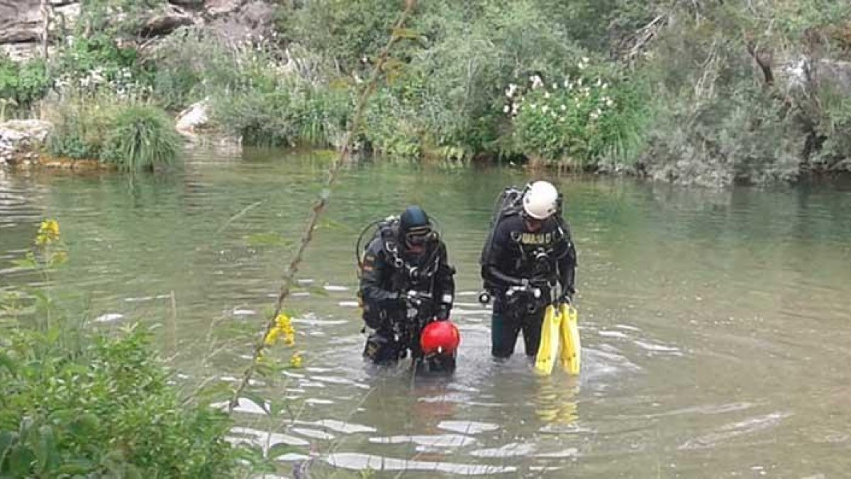 Dos efectivos del GEAS de la Guardia Civil inspeccionan el río con el objetivo de localizar el cuerpo del joven.-GUARDIA CIVIL