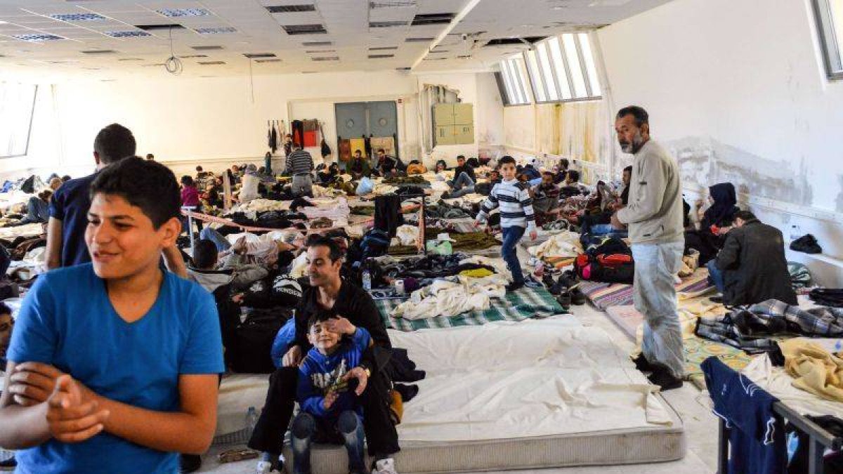 Un grupo de inmigrantes, la mayoría refugiados sirios, en un pabellón deportivo en la isla de Creta.-Foto: AFP / IASON TAVLAS