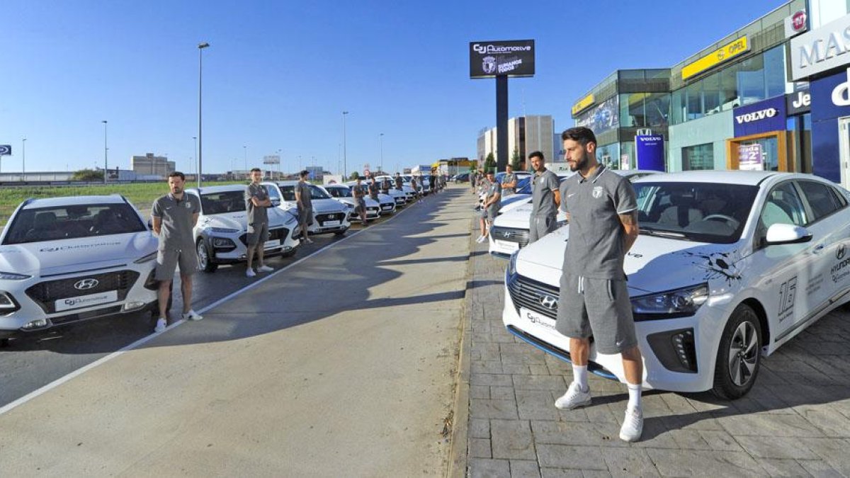 Los jugadores del Burgos posan con los 25 Hyundais cedidos por GJ Automotive.-ISRAEL L. MURILLO
