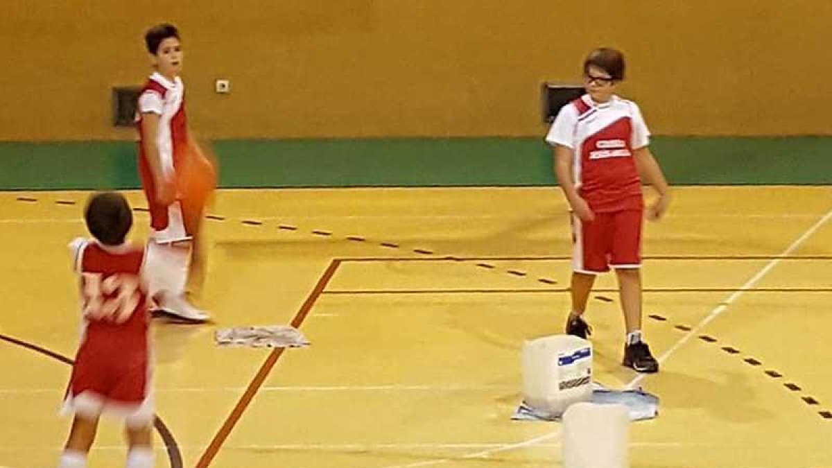 Niños jugando en la pista deportiva de Río Vena con los cubos de agua en medio.-ECB