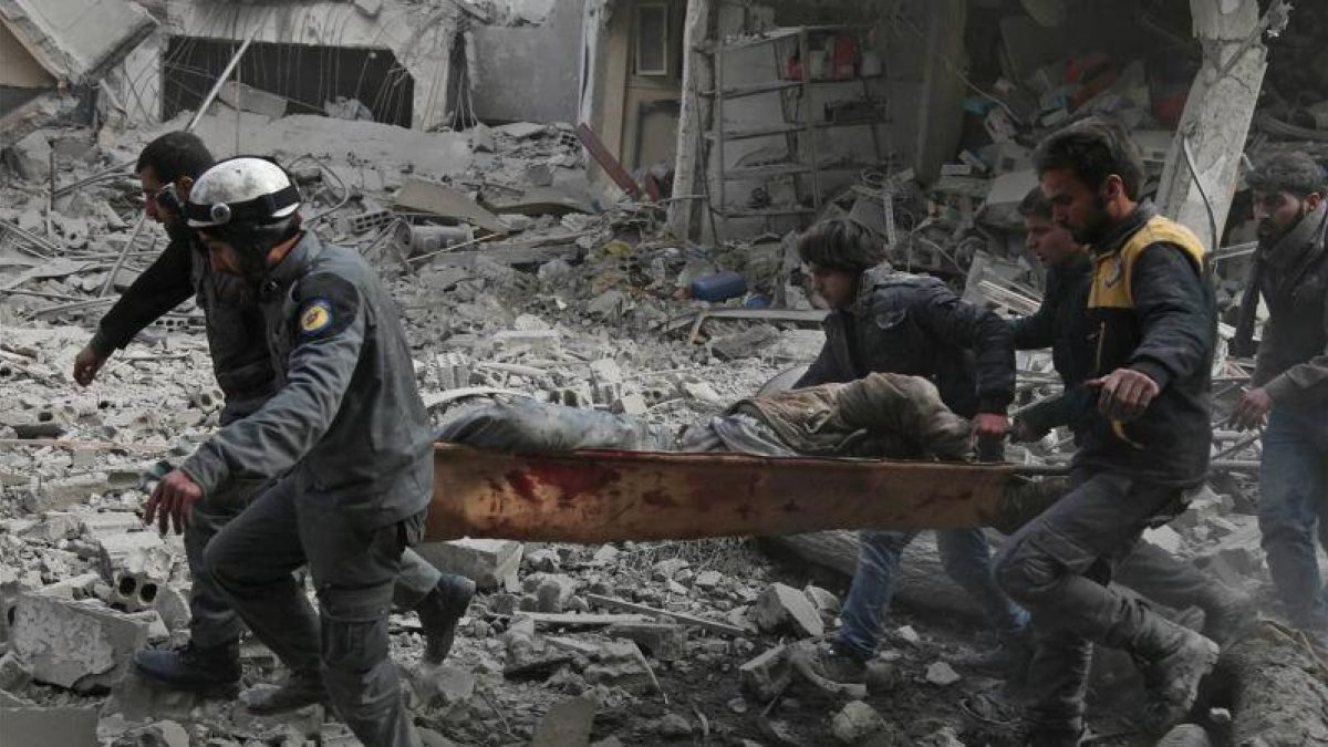 Miembros de Defensa Civil Siria evacuan civiles heridos tras un ataque aéreo a Saqba, en Guta oriental.-ABDULMONAM EASSA (AFP)
