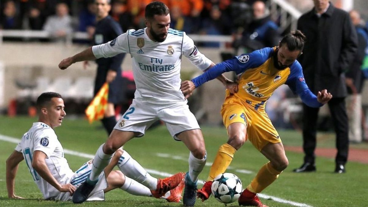 Carvajal, junto a Lucas Vázquez, intenta quitarle el balón a Aloneftis.-REUTERS / ALKIS KONSTANTINIDIS