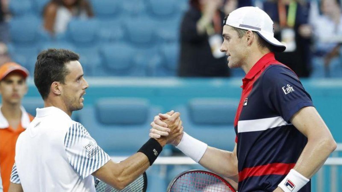 El saludo final entre Bautista Agut e Isner.-EL PERIÓDICO