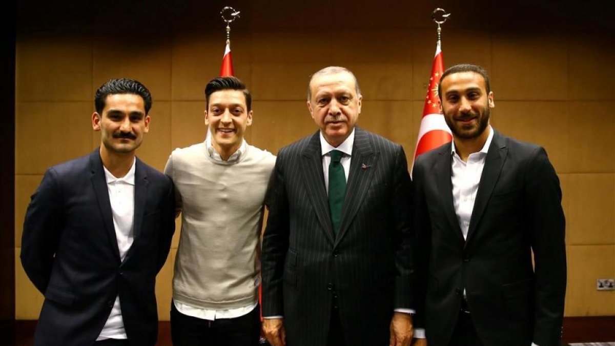 De izquierda a derecha, Gundogan, del City; Özil, del Arsenal; el presidente Erdogan y Tosun, del Everton, en el palacio presidencial.-EL PERIÓDICO