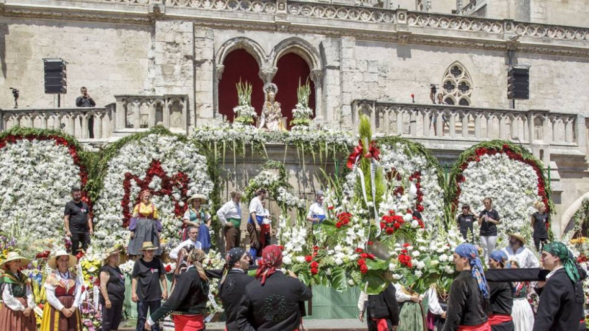 Miembros de la comitiva portan flores para honrar a la virgen.-SANTI OTERO