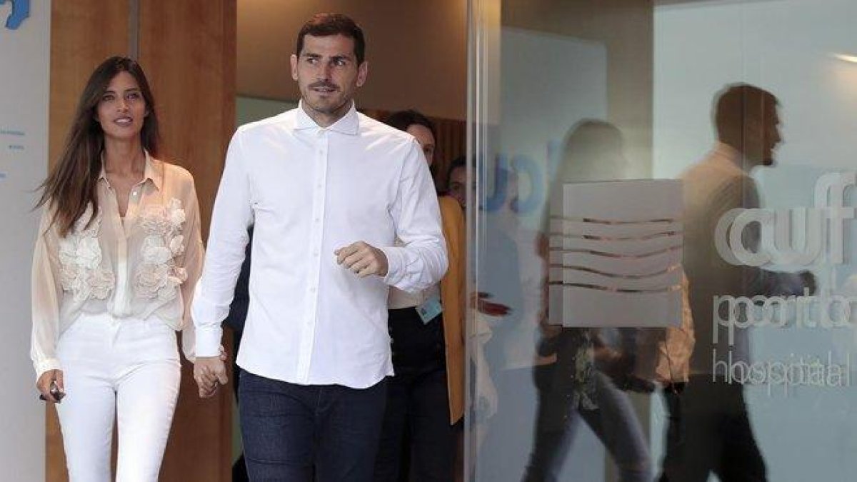Iker Casillas, en el momento de abandonar el hospital acompañado de su mujer, la periodista Sara Carbonero.-AP / LUIS VIEIRA