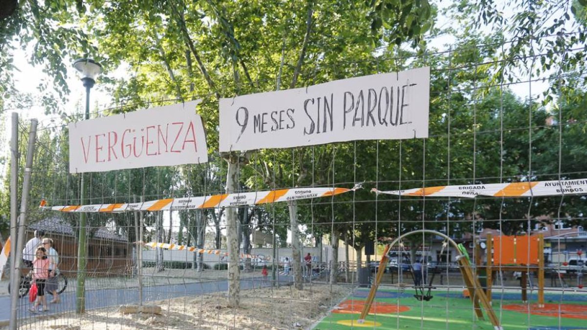 Estado actual del parque infantil con los carteles en primer plano.-RAÚL G. OCHOA