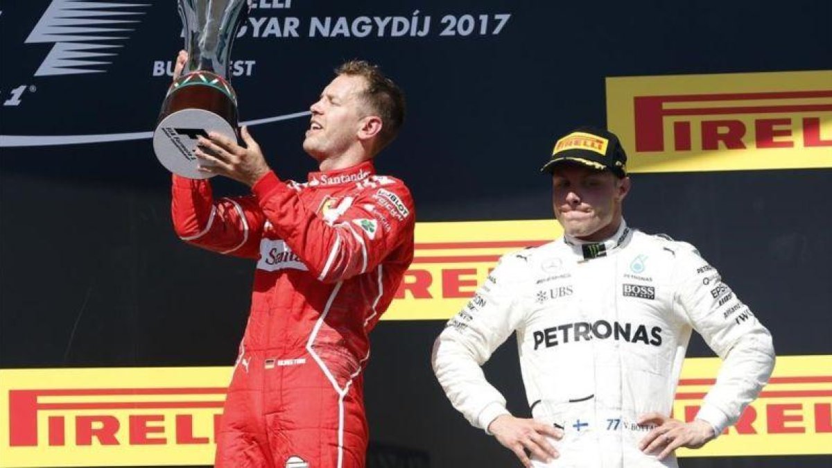 Sebastian Vettel celebra su victoria en Hungría ante Valttri Bottas.-AP / DARKO BANDIC