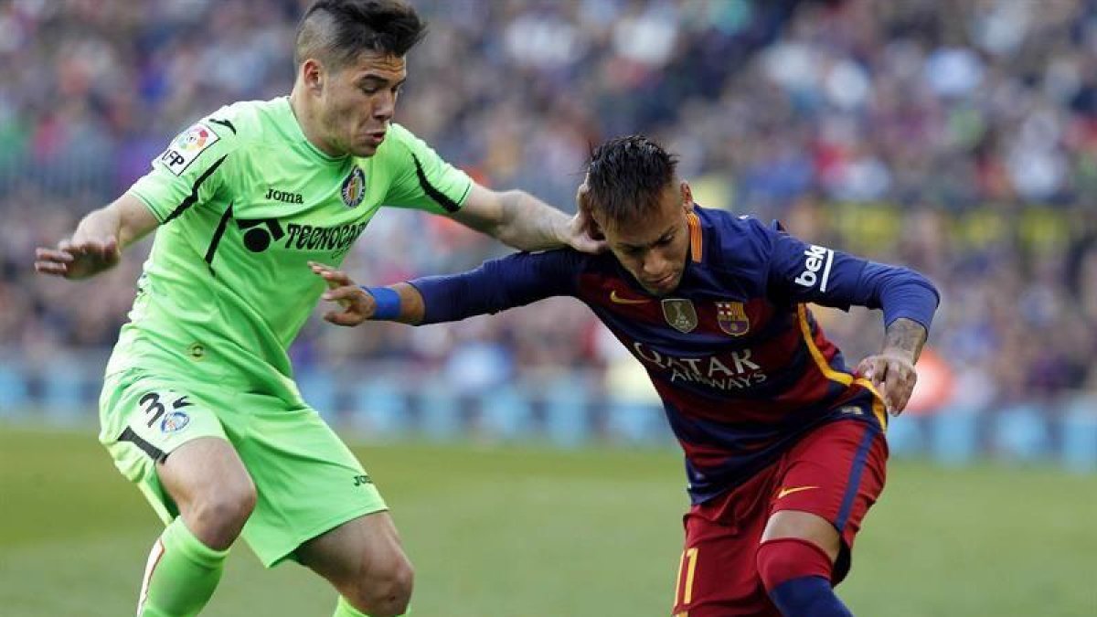 El delantero brasileño del FC Barcelona Neymar da Silva (d) pelea un balón con el defensa del Getafe Emiliano Buendía.-EFE