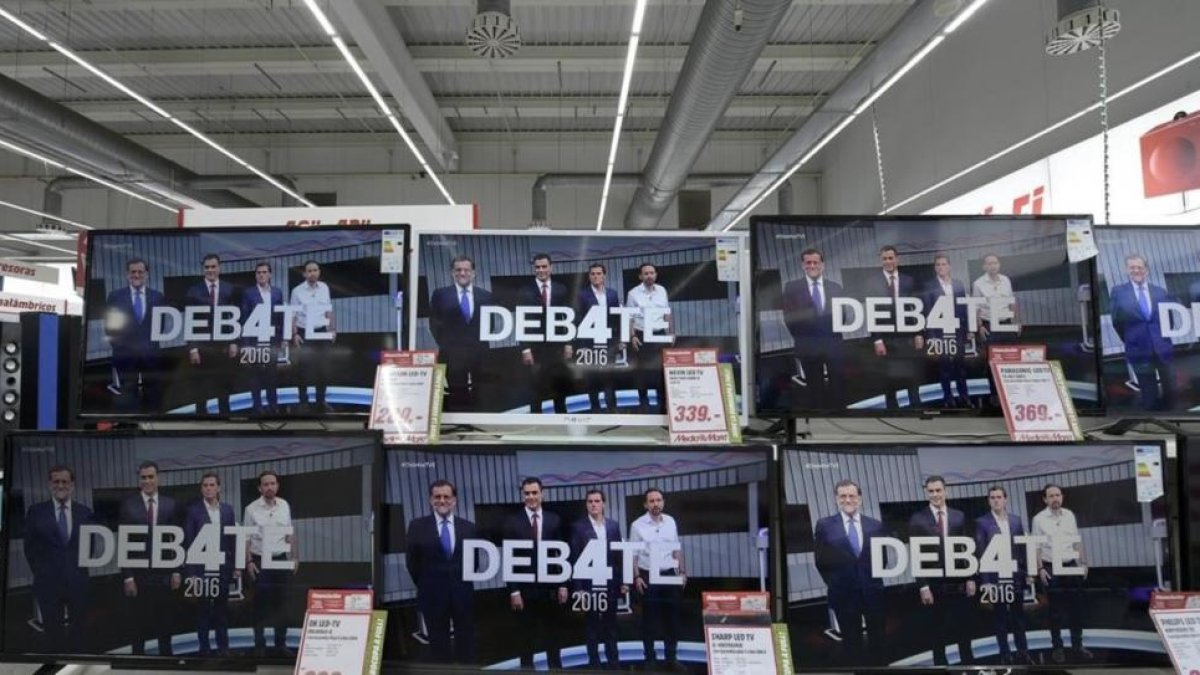 Televisores de un centro comercial ofreciendo el debate a cuatro que emitieron el lunes, 13 de junio, 17 televisiones de toda España simultáneamente.-ELOY ALONSO