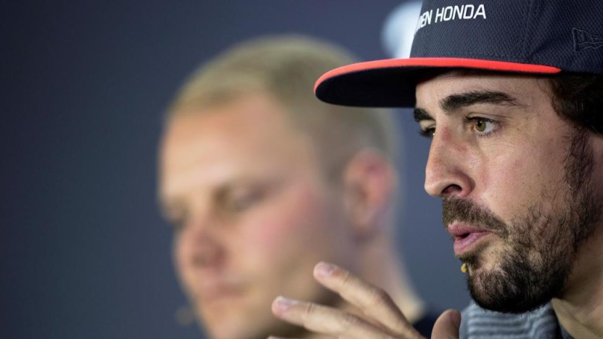 Fernando Alonso con Valtteri Bottas, al fondo, en Abu Dhabi.-VALDRIN XHEMAJ (EFE)