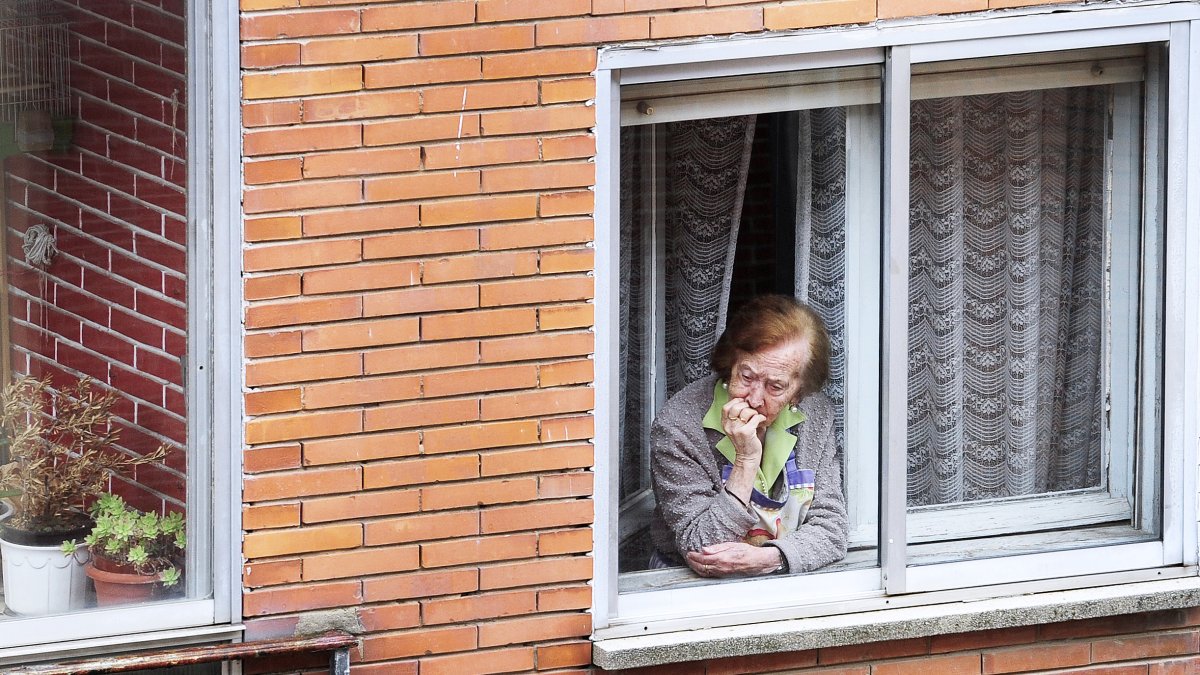 Una anciana se asoma a la ventana de su casa durante estos días de confinamiento. ISRAEL L. MURILLO