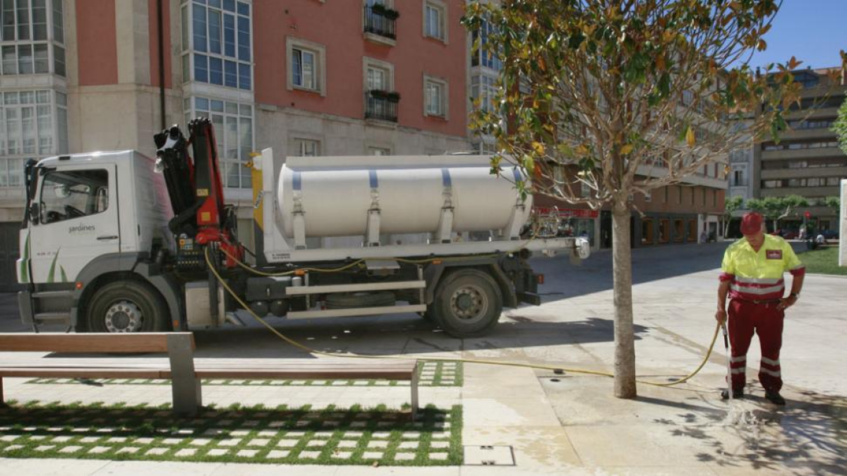 Un operario de parques y jardines riega en la calle Nuño Rasura.-RAÚL G. OCHOA