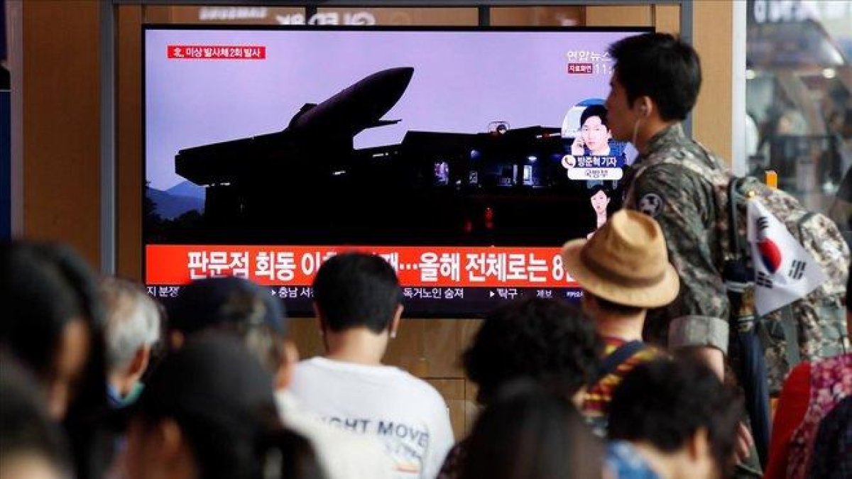 Un grupo de surcoreanos ven este viernes  en la pantalla de un comercio  las ultimas noticias sobre los proyectiles de corto alcance que ha lanzado Corea del Norte desde su costa oriental.-EFE / JEON HEON-KYUN