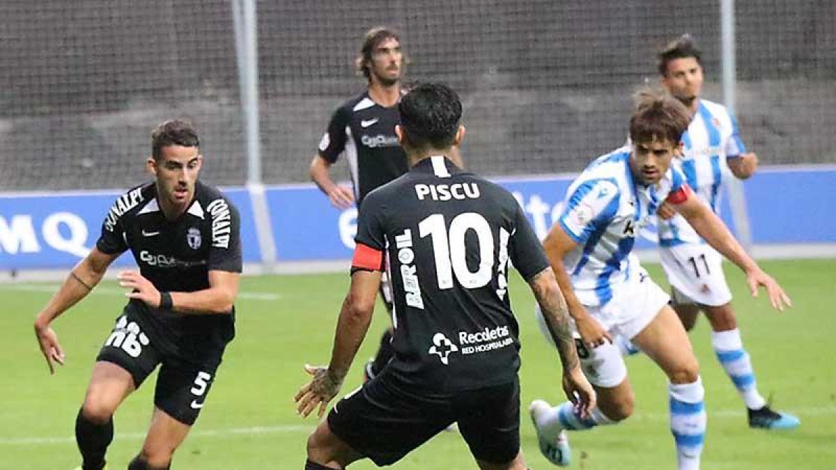 Undabarrena conduce el balón enZubieta en presencia de Pisculichi.-BURGOS CF