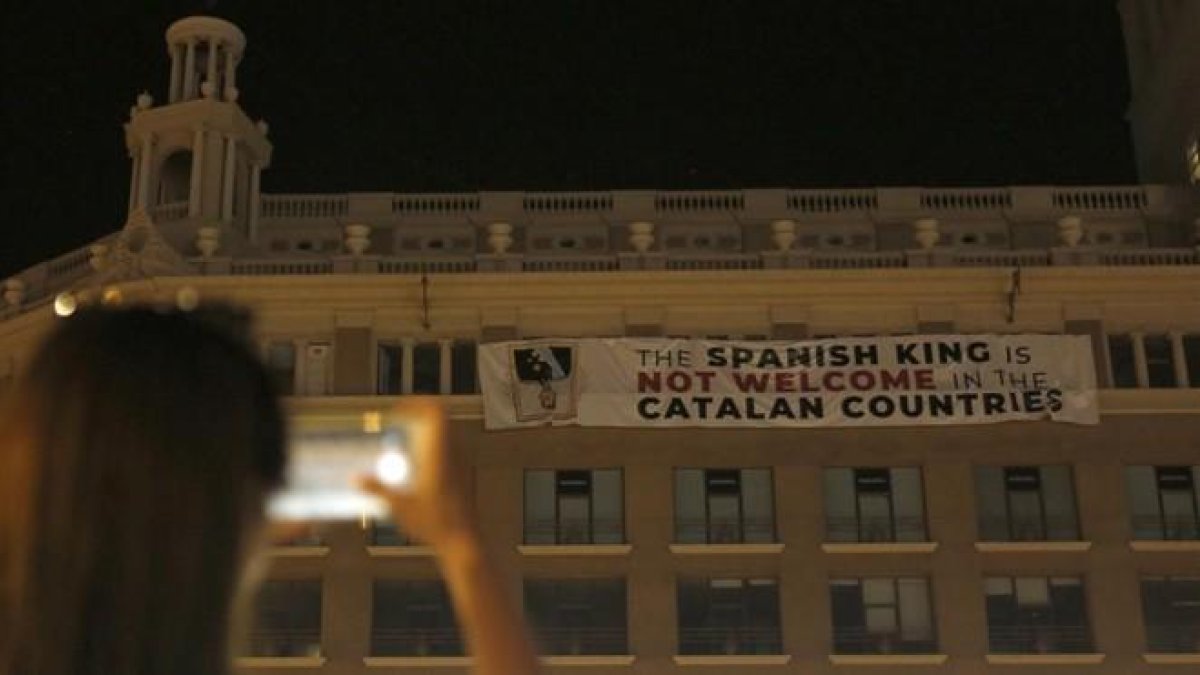 La pancarta que afirma que el Rey no es bienvenido a Catalunya, este jueves por la noche, 16 de agosto, en el edificio de plaça Catalunya, 9. La pancarta que afirma que el Rey no es bienvenido a Catalunya, este jueves por la noche, 16 de agosto, en el edi-ALBERT BERTRAN