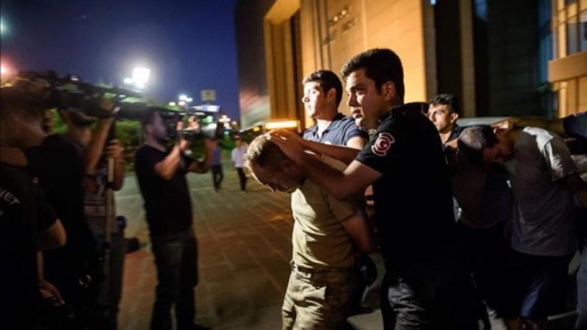 Policías turcos detienen, la noche del sábado, a unos militares del Ejército de Turquía tras el fallido golpe de Estado.-AFP / OZAN KOSE