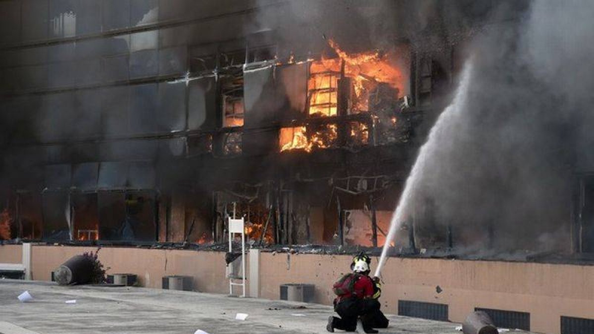Un bombero intenta apagar el fuego de un edificio del complejo de la alcaldía de Chilpancingo.-Foto: AFP / YURI CORTEZ