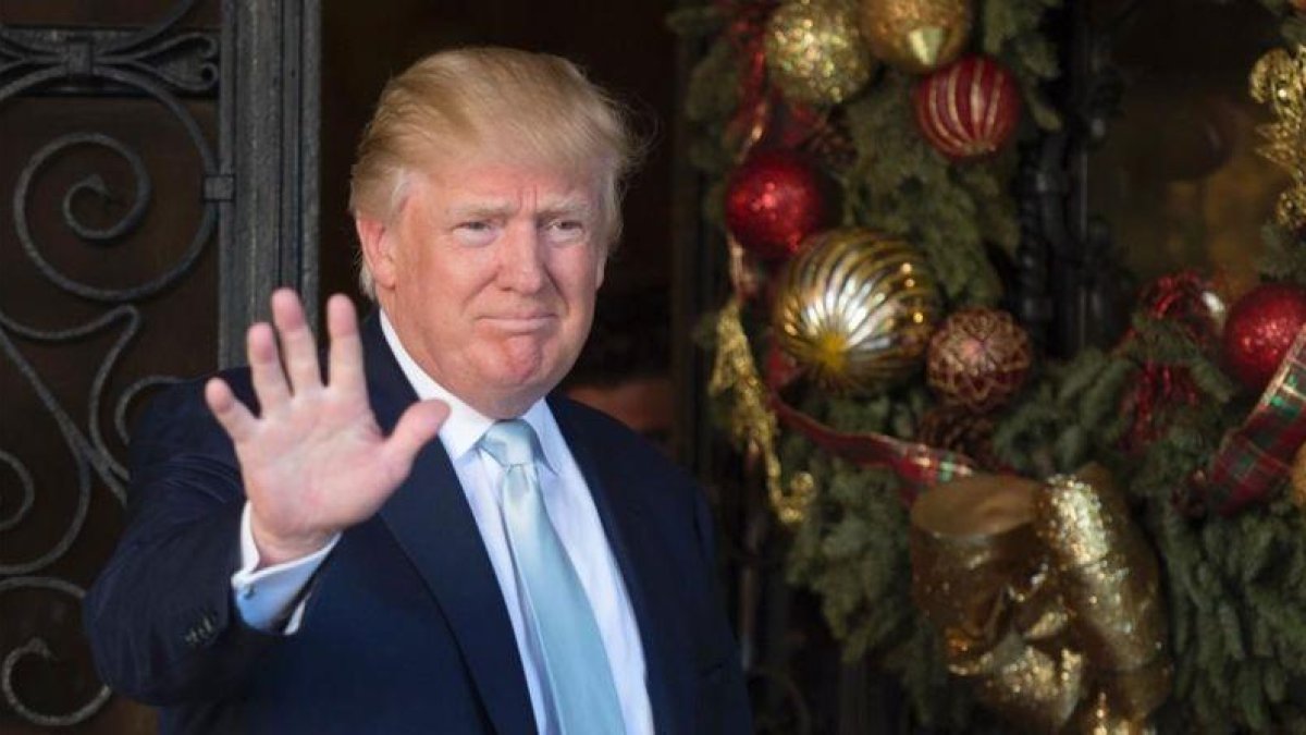 Trump saluda a la prensa tras reunirse con el cofundador del grupo Carlyle, en Mar-a-Lago, en Palm Beach (Florida), el 28 de diciembre.-AFP / DON EMMERT