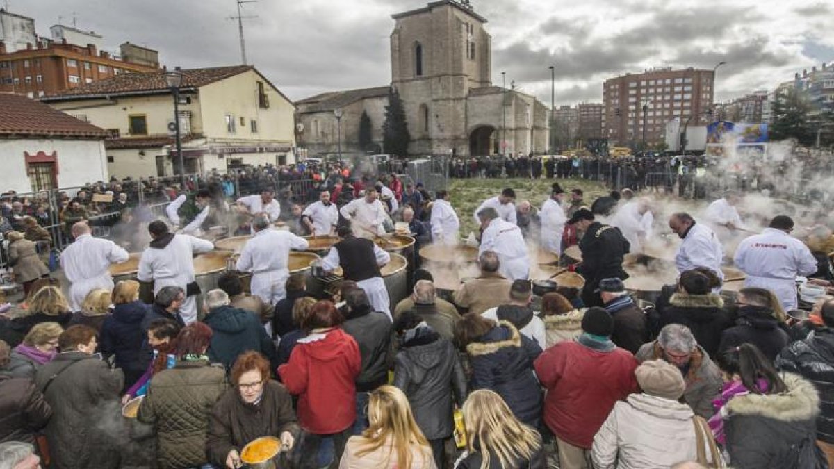Los cofrades se afanan en el cocinado y reparto de los titos mientras algunos hacen cola con sus cazuelas y otros atienden al reparto.-ISRAEL L. MURILLO
