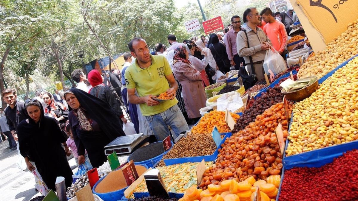 Ciudadanos iranís compran en los negocios del Gran Bazar de Teherán este lunes, horas antes de la entrada en vigor de las nuevas sanciones de EEUU. /-EFE / ABEDIN TAHERKENAREH
