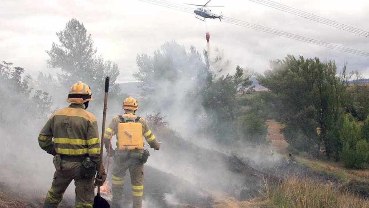 Los incendios han descendido notablemente. En la imagen dos bomberos trabajan en el control de un fuego-ECB