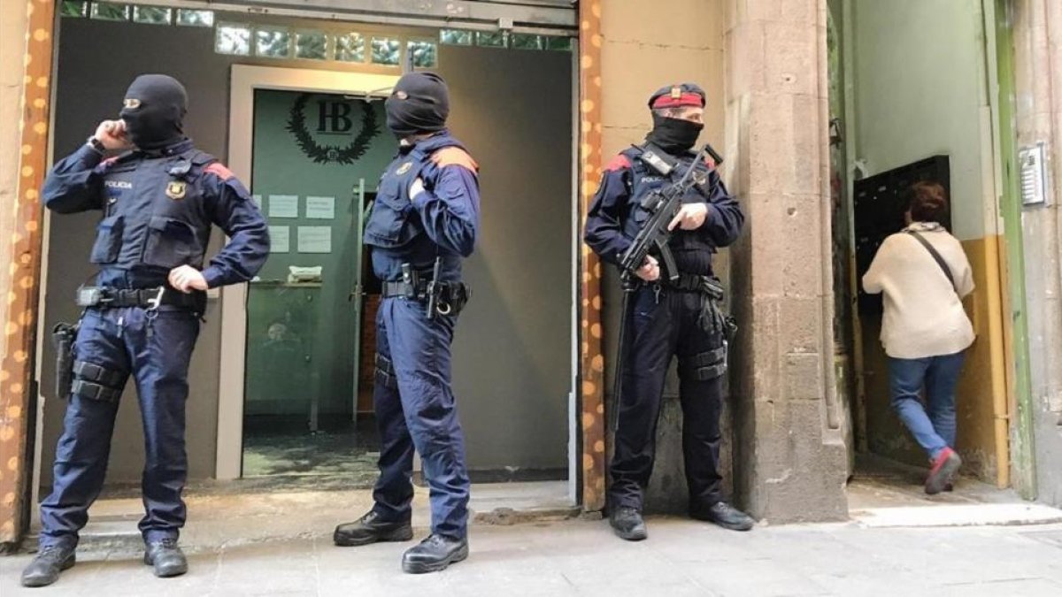 Agentes de los Mossos ante el domicilio registrado en la calle del Carme de Barcelona.-JOAN CORTADELLAS