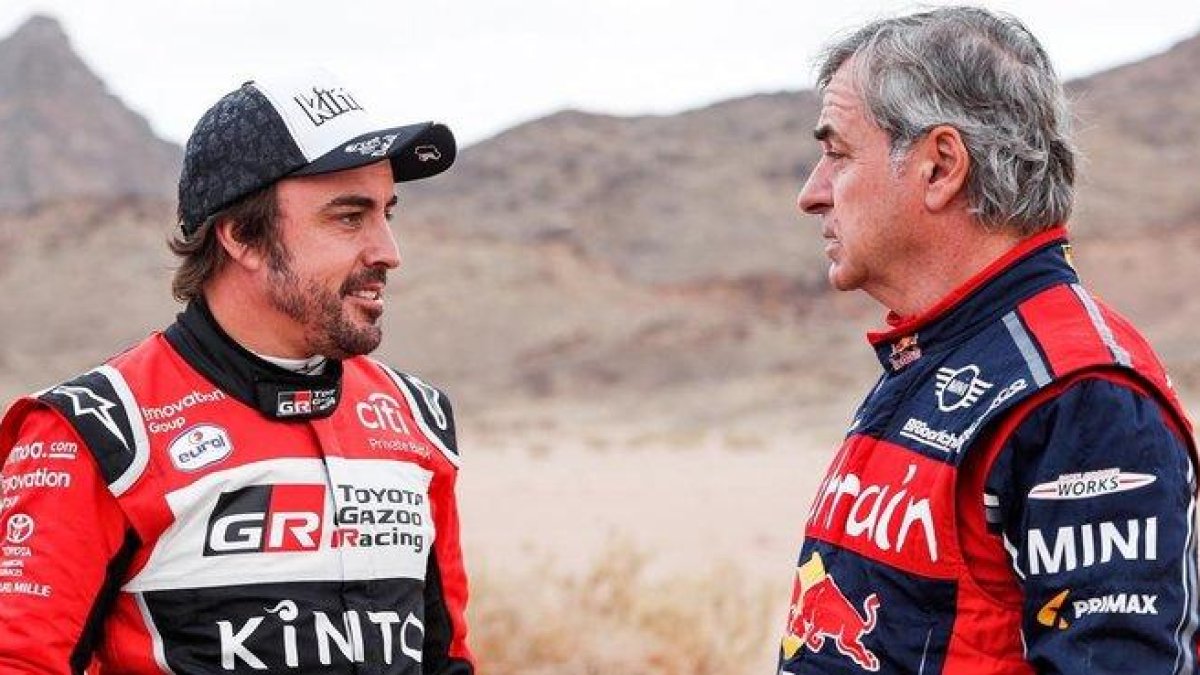 Fernando Alonso y Carlos Sainz conversan tras finalizar la etapa de hoy en el Dakar.-DPPI / FREDERIC LE FLOCH