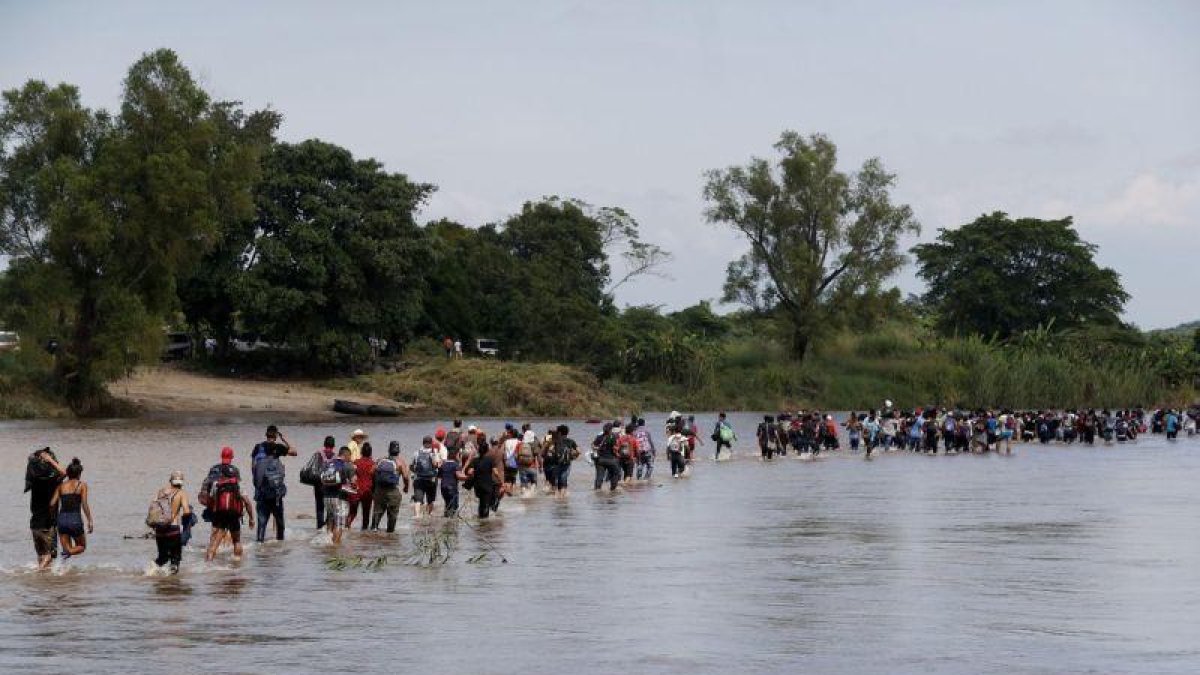 Integrantes de la segunda caravana de migrantes en su mayoria hondurenos cruzan a pie el rio Suchiate.-EFE