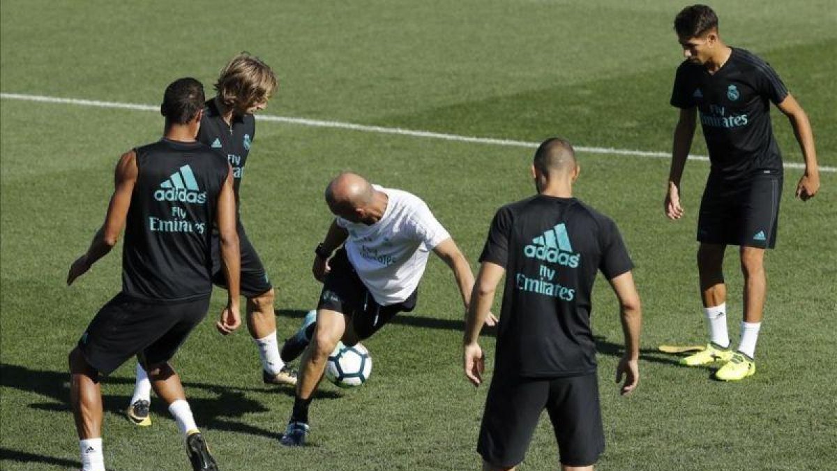 Zidane, en el centro de un rondo durante el entrenamiento de este sábado.-JUAN CARLOS HIDALGO / EFE