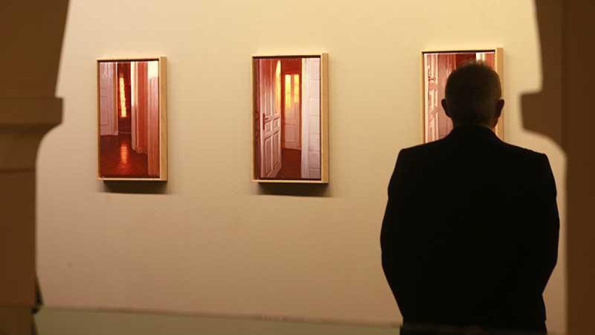 Un visitante observa algunos de los cuadros de la serie 'Luz del amanecer'.-Raúl Ochoa