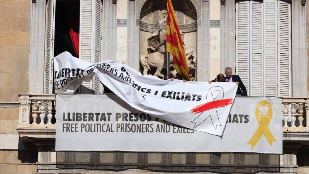 Momento en el que se cambia la pancarta con el lazo amarillo por otra con un lazo blanco en la Generalitat.-FERRAN NADEU