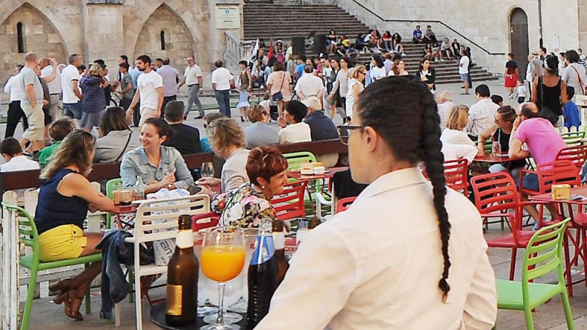 Una camarera se dispone a servir las mesas de terraza de un bar de la capital burgalesa.-ISRAEL L. MURILLO