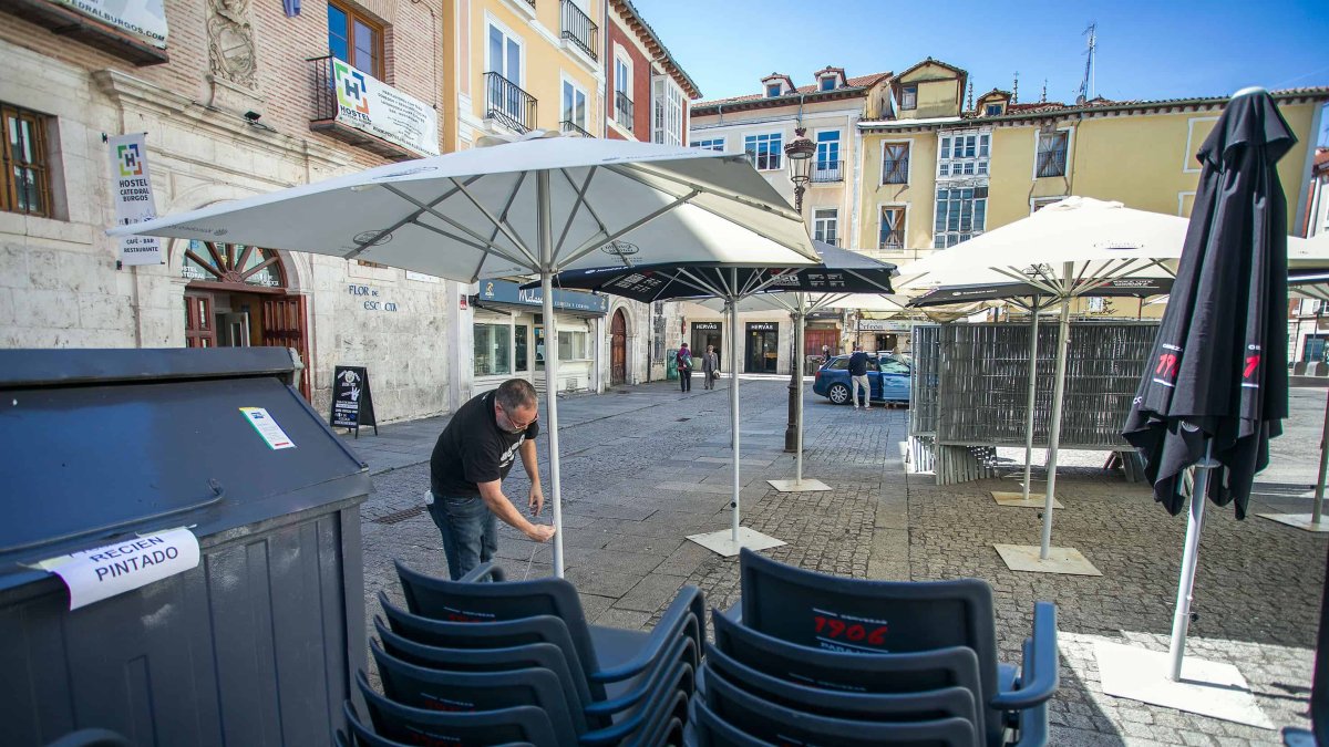 Un trabajador instala las sombrillas para la terraza de hostelería en La Flora. TOMÁS ALONSO