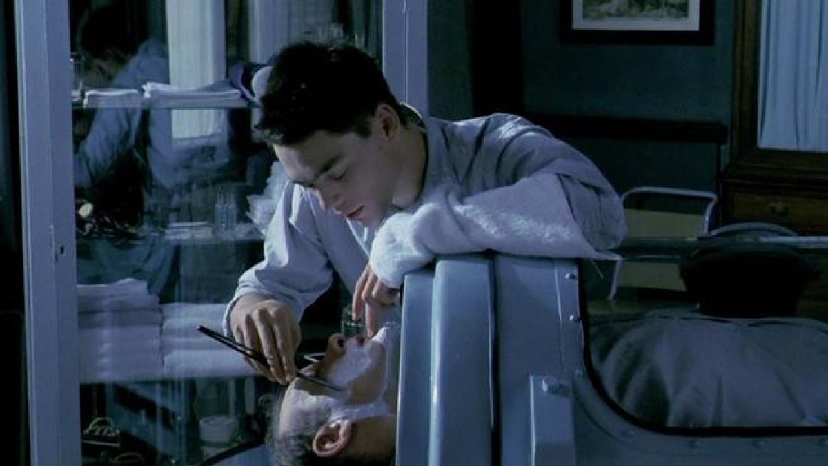 David Sust afeita a Günter Meisner, en una escena de la película 'Tras el cristal'.-